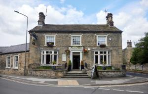 an old brick building with a sign in front of it at Castle Inn by Greene King Inns in Bakewell