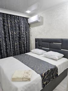 a bedroom with a large bed with white sheets at Апарт Отель MaRi in Shymkent