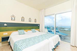a bedroom with a bed and a view of the ocean at HOVIMA La Pinta Beachfront Family Hotel in Adeje