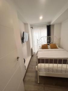 a small bedroom with a bed and a window at Apartaco Apartamentos in Sitges
