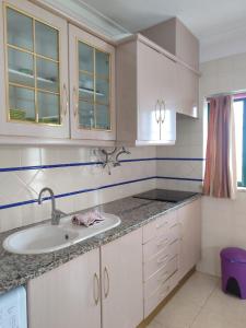 a white kitchen with a sink and a window at Dunas do Alvor by MyLokals in Alvor