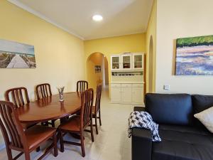 a dining room with a table and a couch at 4º5 Edificio Mar - Casas & Papeis in Armação de Pêra