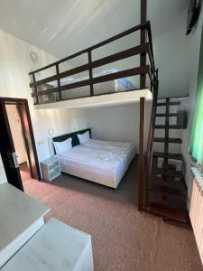 ein Schlafzimmer mit einem Etagenbett und einer Treppe in der Unterkunft Hotel Rudo in Predeal