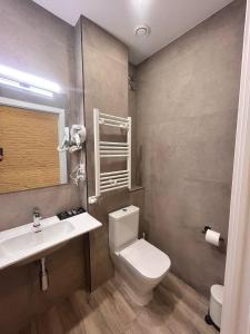 a bathroom with a white toilet and a sink at Apartaco Apartamentos in Sitges +69 photos