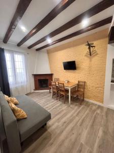 sala de estar con mesa y TV en una pared de ladrillo en Apartaco Apartamentos, en Sitges 69 fotos más