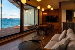 高松市にあるGARDENIA Sunsetのソファがあり海が見えるリビングルーム