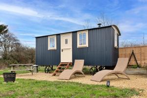a tiny house with two chairs and a table at Finest Retreats - The Flower Hut in Charlton