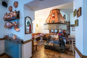 a living room with a fireplace and a dining room at Albergo Alle Alpi in Comeglians