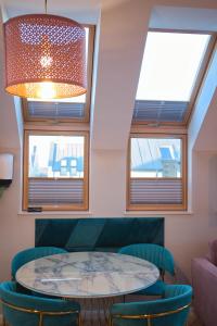 a room with a table and chairs and windows at Apartament Jastrzębia Góra in Jastrzębia Góra