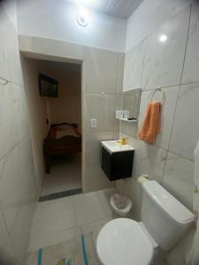 a small bathroom with a toilet and a sink at Sitio Raio De Sol in Cabo Frio
