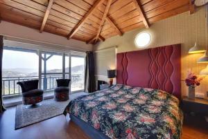 マックトシュワーにある2Bhk Home By Da Alohas Mukhteshwarの大きなベッドと大きな窓のある寝室