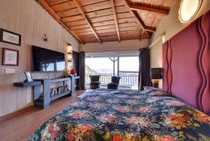 マックトシュワーにある2Bhk Home By Da Alohas Mukhteshwarのベッドと机と窓のある寝室