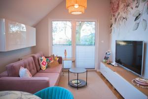a living room with a couch and a flat screen tv at Apartament Jastrzębia Góra in Jastrzębia Góra