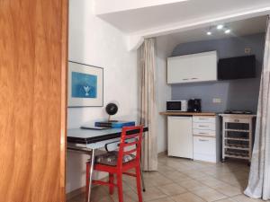 małą kuchnię z czerwonym krzesłem i biurkiem w obiekcie Studio Campanule Provence Verdon w mieście Riez