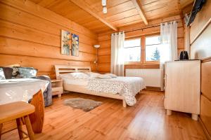 a bedroom with two beds in a wooden cabin at U Pabinów in Kościelisko