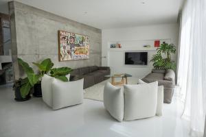 a living room with white furniture and a couch at Sojourn in Tumbak Bayuh
