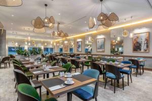 a restaurant with wooden tables and chairs and lights at Wyndham Wroclaw Old Town in Wrocław