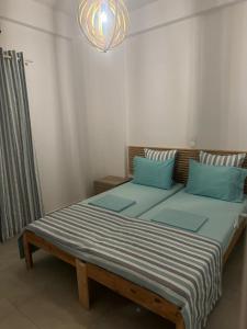 a large bed with blue pillows in a room at Astypalaia Bella Vista Houses Blue, Verde, Veranda Sunset in Astypalaia Town