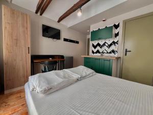 a bedroom with a white bed and a green door at Just Home in Varna City