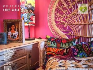 a room with pink walls and a chair with a picture at HOTEL ALTES THEATER Heilbronn in Heilbronn
