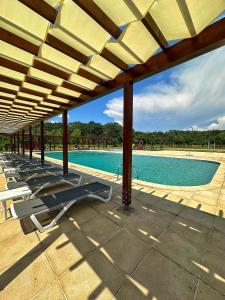 a swimming pool with lounge chairs under a pavilion at Casa Vlasia in Snagov