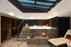 a bathroom with a bath tub and stairs in a room at Wyndham Wroclaw Old Town in Wrocław +43 photos