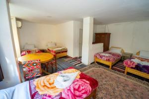 a room with several beds and a table and a room with a table and chairs at Venus Hotel Luxor 日本人 大歓迎 in Luxor