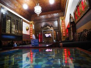 a bar with a glass table in a room at Hotel des Oudaias in Rabat