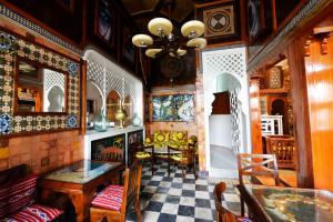 sala de estar con mesa, sillas y lámpara de araña en Hotel des Oudaias en Rabat