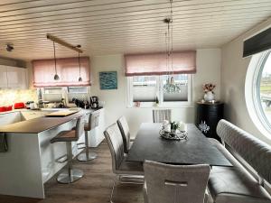 a kitchen and dining room with a table and chairs at Lille Fjord Hus in Schleswig