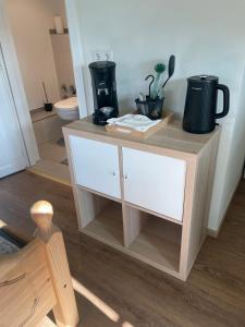 a wooden cabinet with a coffee maker on top of it at Home Sweet Home in Buchenbach +20 photos