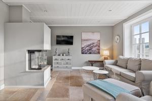 Una sala de estar con un sofá y una chimenea. en Reetdachhaus Reetkoje Reetdachhaus Reetkoje II, en Süderhöft
