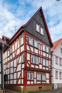 a red and white building with a black roof at Ferienwohnung Altstadtblick in Alsfeld