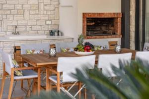 a wooden table with chairs and a bowl of fruit at Luxury Five Bedroom Villa With Pool and Sunset View in Zaton