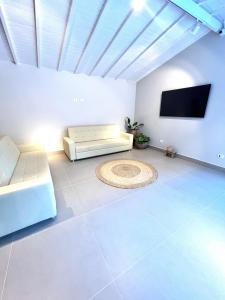 a living room with a bed and a flat screen tv at Pousada Cancun Boutique in Guarujá