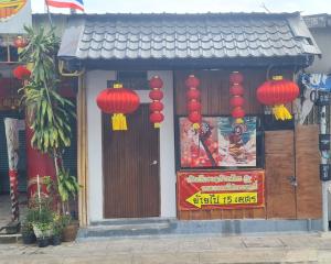 un edificio con lanterne rosse e un cartello sopra di Little Home in Town a Ban Lo Long