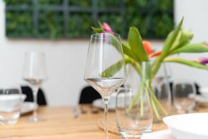 a table with two wine glasses and a vase of flowers at KeyHosting Apartment Zentral Parkplatz in Aschaffenburg