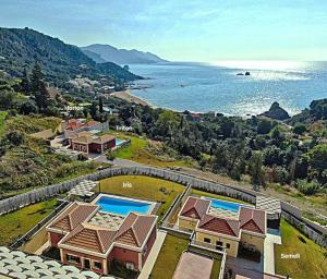 una vista aérea de una casa y del océano en Άρκτος ΟΕ, en Pelekas