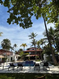 a group of benches in a park with palm trees at Pousada Cancun Boutique in Guarujá