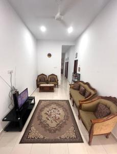 a living room with couches and a flat screen tv at Dang Anum Homestay Kuantan Airport HalalHome in Kuantan