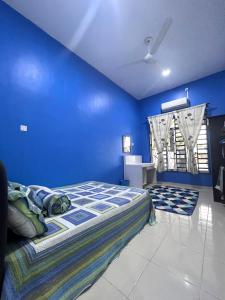 a blue bedroom with a bed and a blue wall at Dang Anum Homestay Kuantan Airport HalalHome in Kuantan
