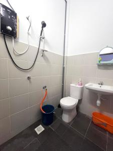 a bathroom with a shower and a toilet and a sink at Dang Anum Homestay Kuantan Airport HalalHome in Kuantan
