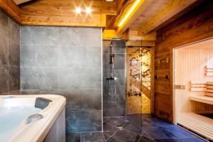 un bagno con vasca e doccia di Les Couadzous Samoëns Centre, Sauna, Jacuzzi, 6 chambres, 7 salles de bains, 16 pers 250 m2 a Samoëns Altre 15 foto