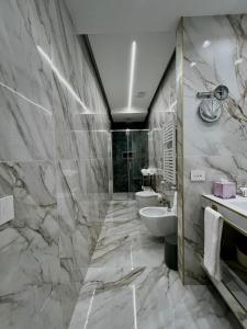 a bathroom with two toilets and a sink and a shower at Golden House Cinecittà in La Romanina