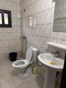 a bathroom with a toilet and a sink at Villa cité in Zogbégan +2 photos