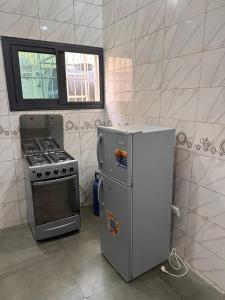 a kitchen with a stove and a refrigerator at Villa cité in Zogbégan