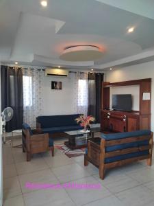 a living room with a blue couch and a tv at Résidence Ahitantsoa Appartement à l'étage in Mahajanga +7 photos