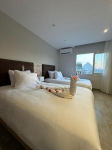 a hotel room with two beds and a large window at Khufu Pyramids View Inn in Cairo