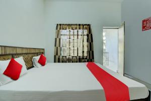 ラーイプルにあるSuper Hotel O Pragya Newのベッドルーム1室(大型ベッド1台、赤と白の枕付) +17枚の写真