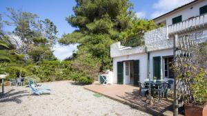 a patio with a table and chairs in front of a house at Appartamenti Villa Anna - Goelba in Capoliveri